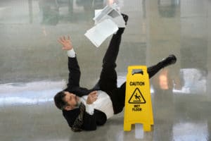 man suffering a slip and fall accident on a wet floor
