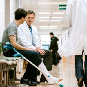 man on crutches talking to a doctor after a slip and fall accident