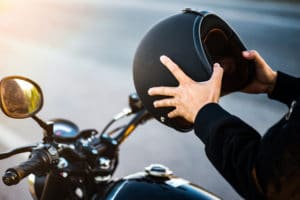 motorcycle rider holding helmet