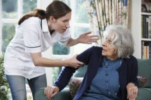 elderly woman experiencing nursing home abuse from a staff member