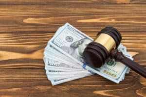 gavel on top of hundred dollar bills from a motorcycle accident settlement