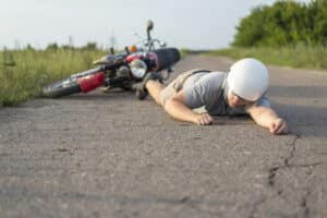man lying on the road after a motorcycle accident