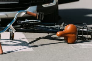 broken bicycle and car on road after a car accident