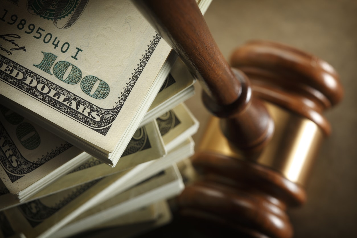 gavel and a stack of 100 dollar bills after dog bite settlement